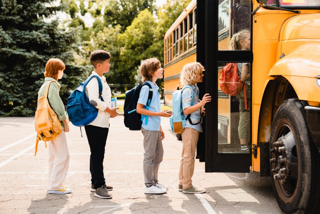 children climbing onto. their school bus