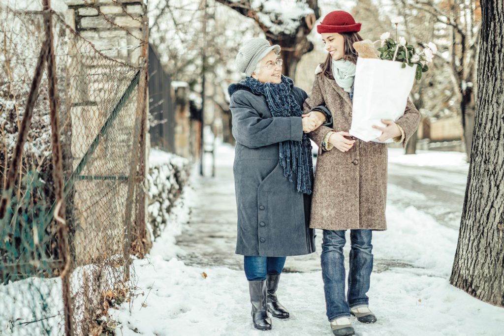 One woman helps another with her groceries