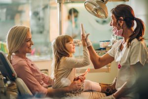 young girl high-fives her dentist