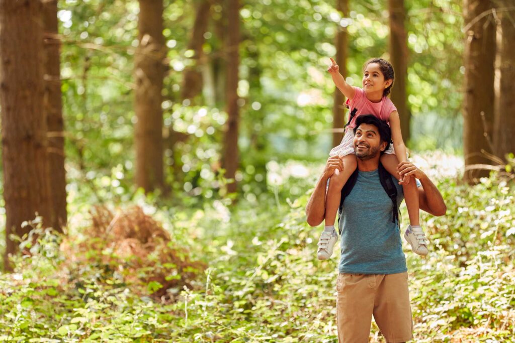 A father and daughter exploring a forest