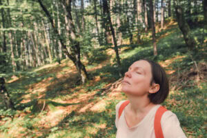 Female hiker taking breath of fresh air in forest
