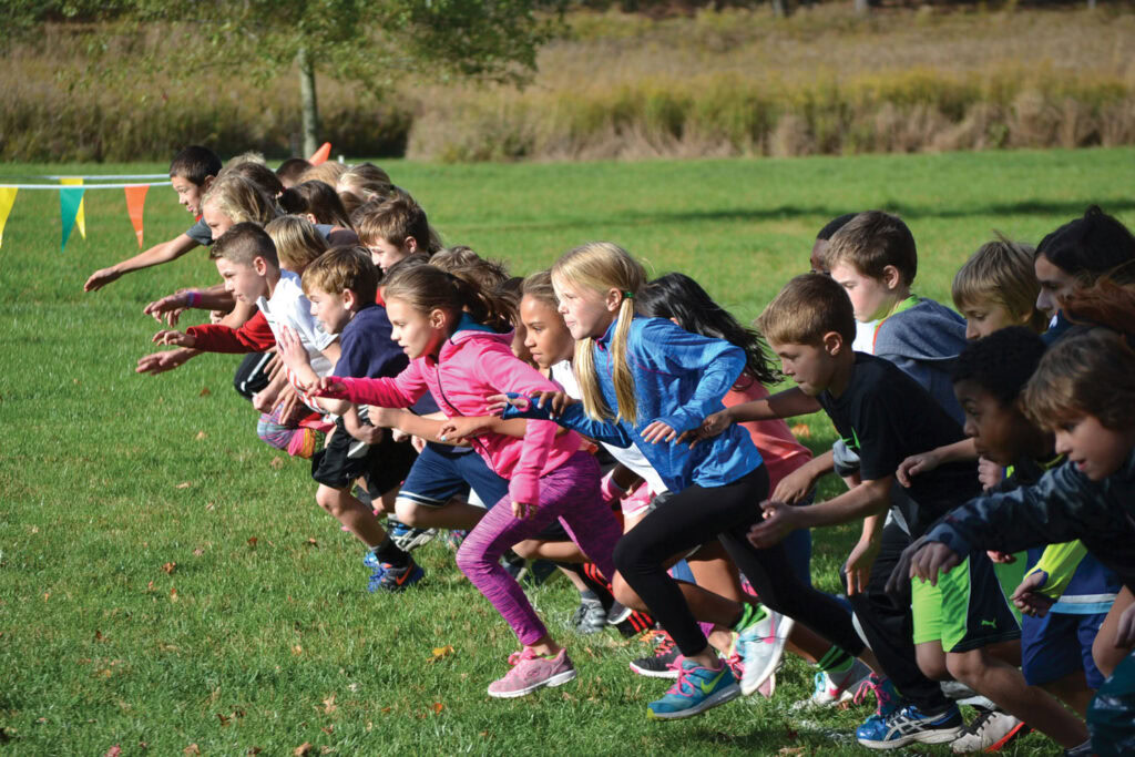 a line of children starting a foot race on a field